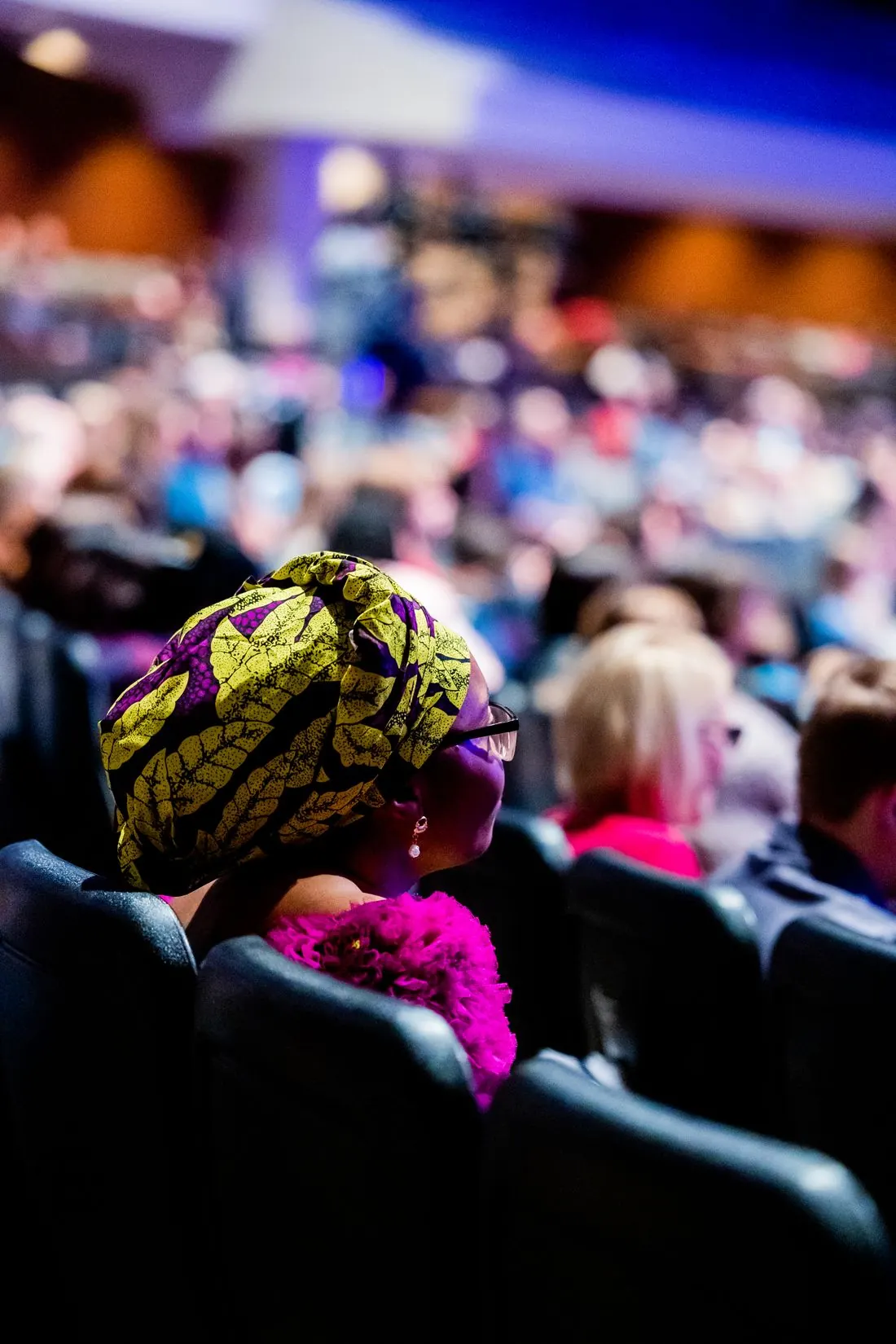 A woman in a colourful headscarf in a conference audience
