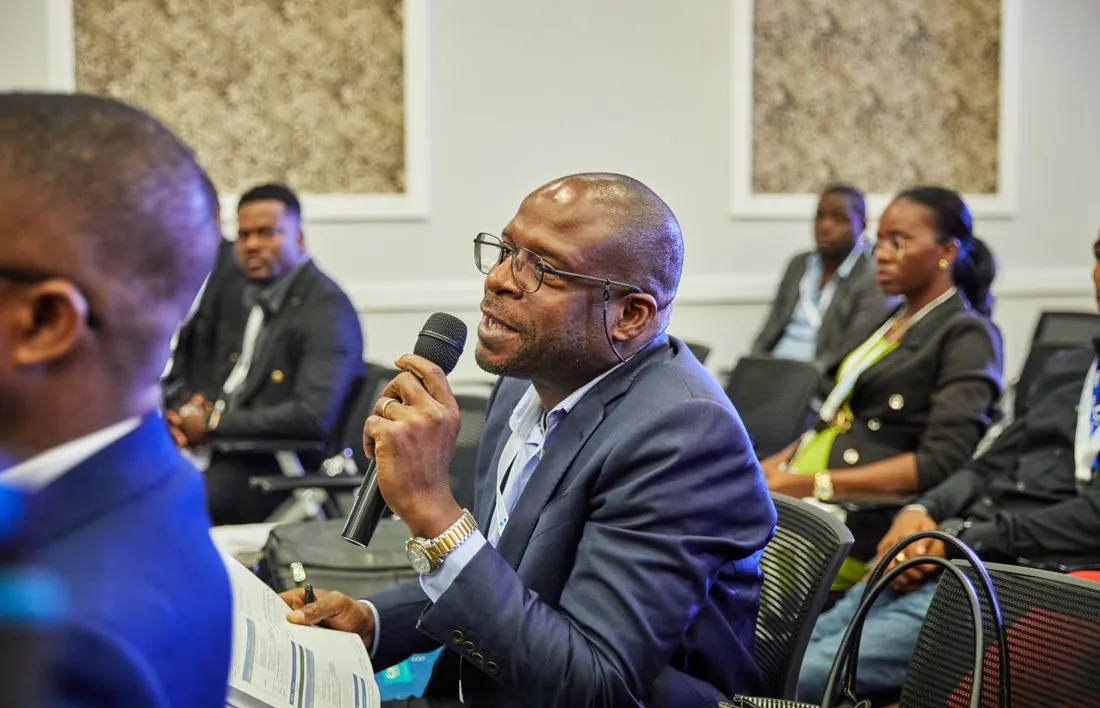 A delegate speaking into a microphone during a forum session