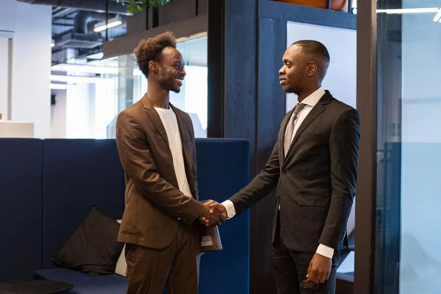 Two businessmen shaking hands on a deal in an office