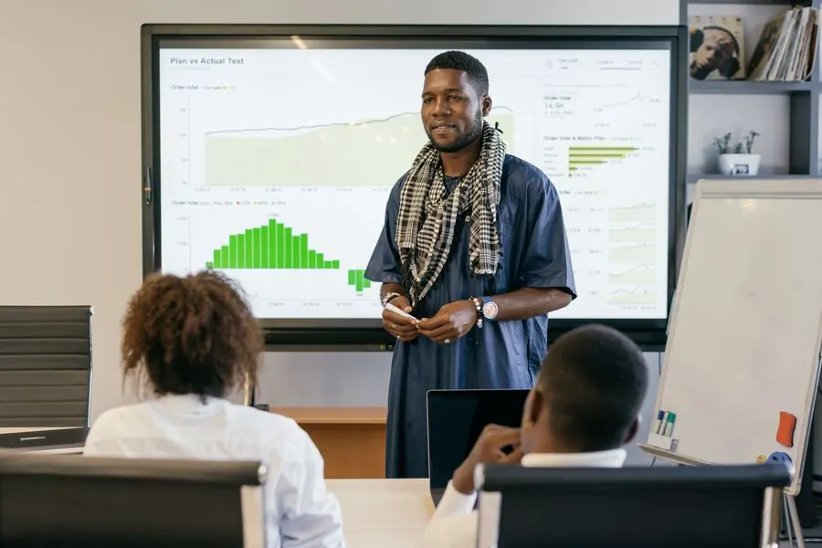 A man presenting a chart to colleagues in a meeting room